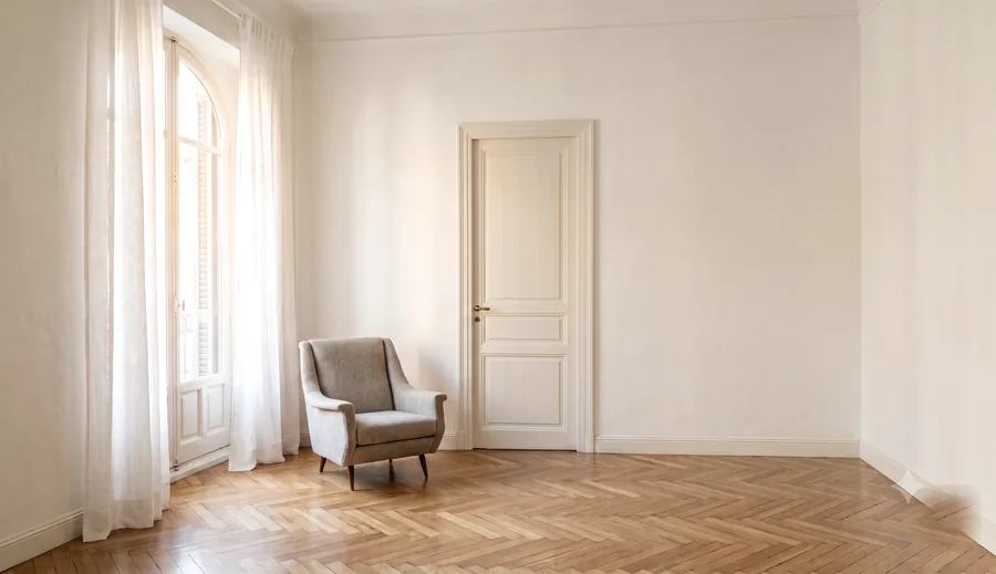 A quiet living room in a classic Madrid apartment, morning light through a balcony window